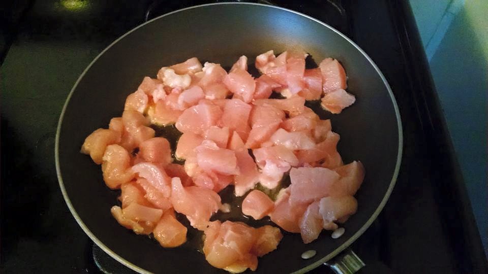Diced chicken cooking in pan