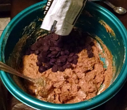 Cookie dough with chocolate chips being poured in